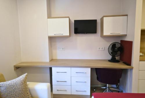 a room with a desk with a tv on a wall at Uçar Royal Hotel ve Konferans Salonu in Sile