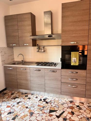 a kitchen with wooden cabinets and a stove top oven at Studio di Omero in Verona