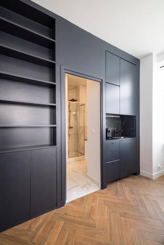 - un salon avec des murs noirs et du parquet dans l'établissement Modern apartment in Nation, à Paris