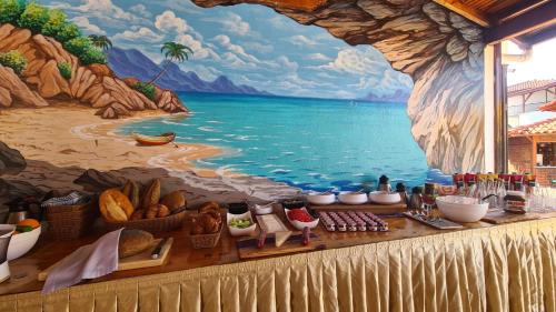 a mural of a painting of a beach with food on a table at Palma Rosa Hotel in Kemer