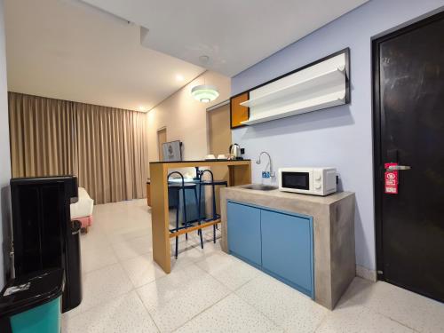 a room with a kitchen with a microwave on the wall at Treehita Cabin Jogja in Sleman