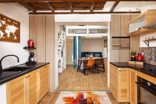 une cuisine avec des placards en bois et une salle à manger dans l'établissement La Maison du Plaisir, à Gruissan