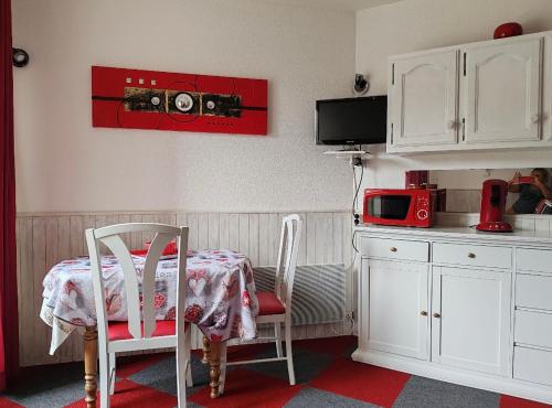 a kitchen with a table and two chairs and a microwave at Studio cosy avec vue rivière et montagne in Barèges