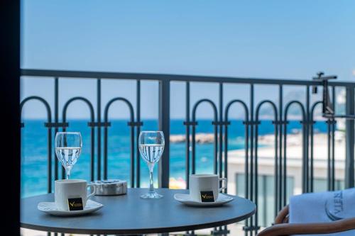 a table with two glasses of wine on a balcony at Vienna Luxury Apartments in Dobra Voda