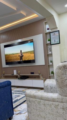a living room with a flat screen tv on a wall at Twelve04 Apartments in Ibadan