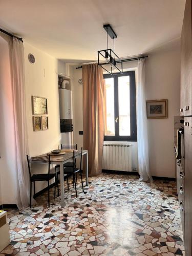 a dining room with a table and chairs and a window at Studio di Omero in Verona