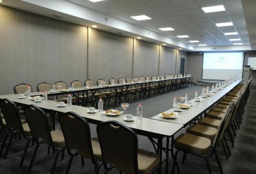 a conference room with long tables and chairs and a screen at Uçar Royal Hotel ve Konferans Salonu in Sile