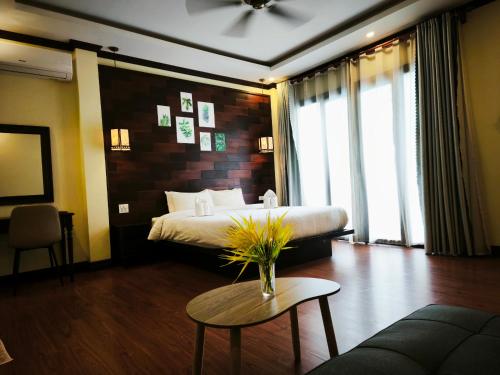 a hotel room with a bed and a coffee table at Meunna Boutique Hotel in Luang Prabang