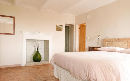 a white bedroom with a large bed and a vase at Panoramic Monferrato Villa With Garden & Amazing Views in Murisengo