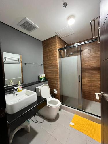 a bathroom with a toilet and a sink and a shower at Modern Pet Friendly 1br Condo with Balcony near AIRPORT MOA & OKADA Pasay Staycation WFH ready Free Pool Acces Gym and Sauna in Manila