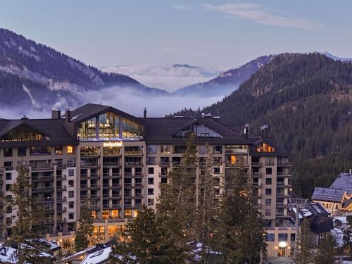 a large building with mountains in the background at Swissôtel Damian Jasna in Demanovska Dolina