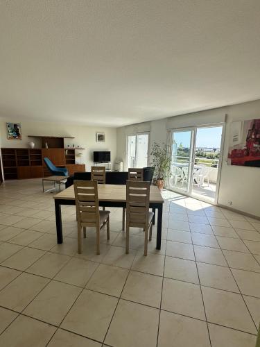 un salon avec une table et des chaises de salle à manger dans l'établissement Appartement vue mer avec garage, à Aytré