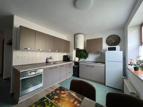 a kitchen with white cabinets and a white refrigerator at Apartmán 1 jar-leto in Martin