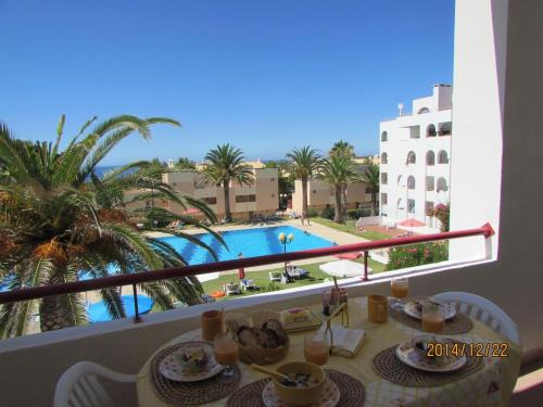 a balcony with a table and a view of a pool at Quinta das Palmeiras - T2 in Porches