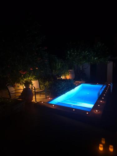 a swimming pool at night with a person sitting next to it at Villa Anthemida Chania in Ayiá