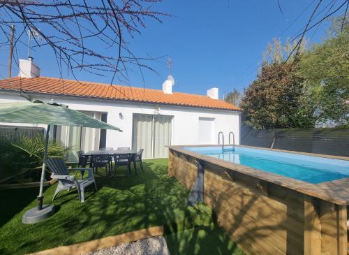 une cour arrière avec une piscine et une maison dans l'établissement La Maraîchine Ensoleillée, à Saint-Jean-de-Monts