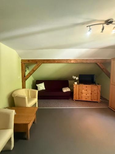 a living room with a couch and a table at FALEZA Dębina in Debina