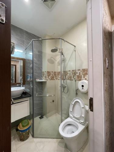 a bathroom with a toilet and a glass shower at GOLD CITY Hotel in Tây Ninh