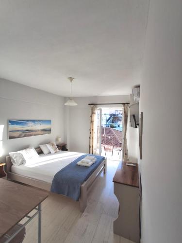 a bedroom with a large bed and a table at Tasias apartments in Lixouri