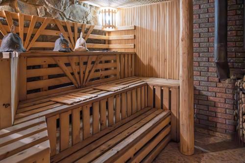 a sauna with wooden benches and a brick wall at Котеджі "У Яни" in Yablunytsya