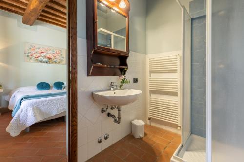 a bathroom with a sink and a bed in a room at CASALE TEATRO 10, Emma Villas in Laiatico