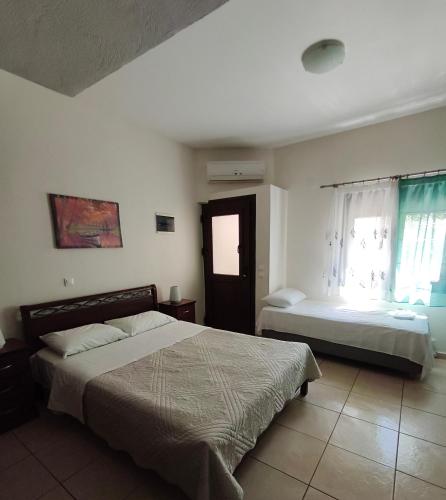 a bedroom with two beds and a window at Daniela Apartments in Nea Roda