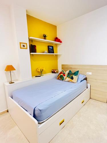 a bedroom with a bed with a yellow wall at Duna Sunset - Ganador Traveller Awards 2026 in Daimuz