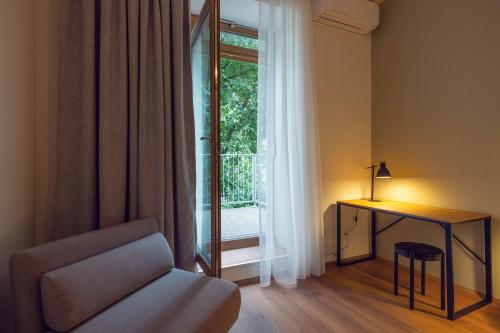 a living room with a chair and a table and a window at LeonArt Living 12 in Graz