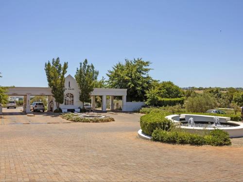 a building with a fountain in the middle of a driveway at Winelands Golf Lodges 24 in Stellenbosch