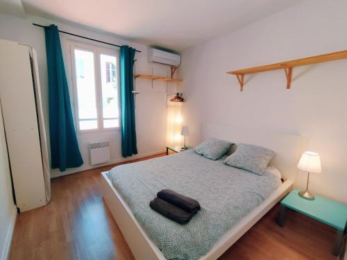 une chambre avec un grand lit avec des rideaux bleus dans l'établissement Mounette Etxea, à Biarritz