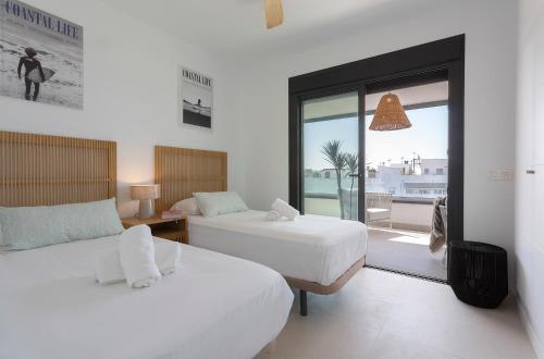 une chambre avec deux lits et une vue sur l'océan dans l'établissement Salitre Apartment Luxury Oceanfront with Pool Terrace and Private Parking, à Conil de la Frontera