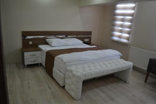 una camera con un grande letto con testiera in legno di Divrigi Kosk Hotel a Divriği