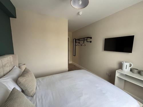 a bedroom with a bed and a flat screen tv at East Halton Hotel in East Halton