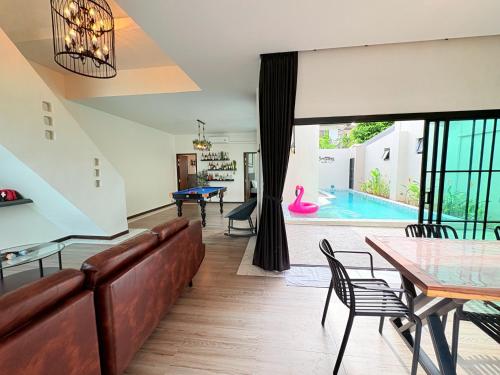 a living room with a couch and a table and a pool at Brittany Private Pool Villa-Pattaya in Na Jomtien