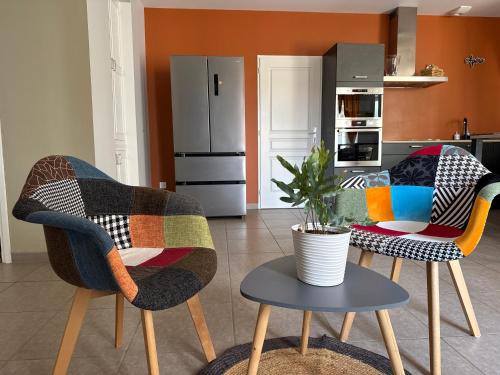a living room with two chairs and a table at Gîte du Puits Olivier 10 personne chaleureux 3 étoiles in Airvault