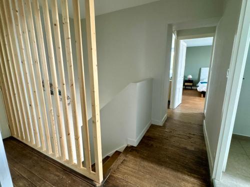 a staircase in a room with white walls and wood floors at Gîte du Puits Olivier 10 personne chaleureux 3 étoiles in Airvault