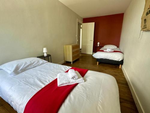 a bedroom with two beds with red and white sheets at Gîte du Puits Olivier 10 personne chaleureux 3 étoiles in Airvault