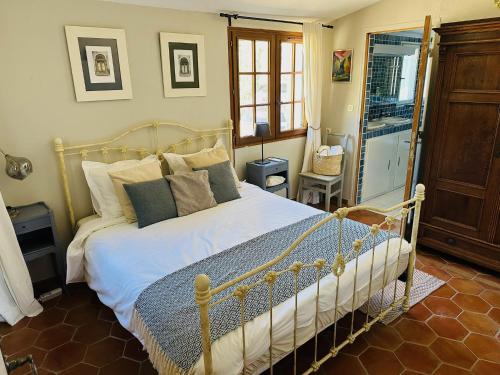 une chambre avec un lit avec des draps blancs et des oreillers dans l'établissement Villa Libellule, à Cotignac