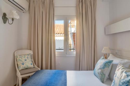 a bedroom with a bed and a chair and a window at La Goleta in Llança
