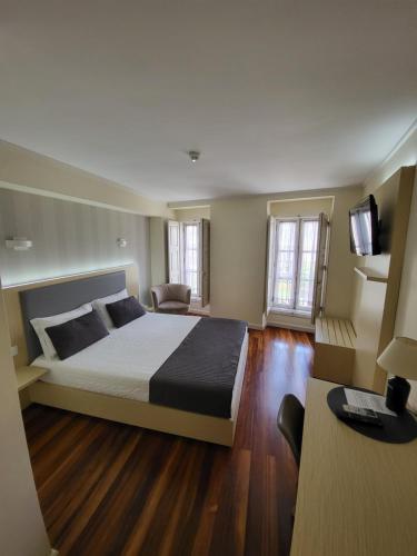 a bedroom with a large bed and a television at Hotel Residencial Dora in Braga