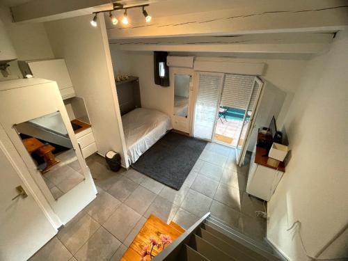 Cette petite chambre comprend un lit et un réfrigérateur. dans l'établissement Appartement tout équipé village naturiste à 100 m, au Cap d'Agde