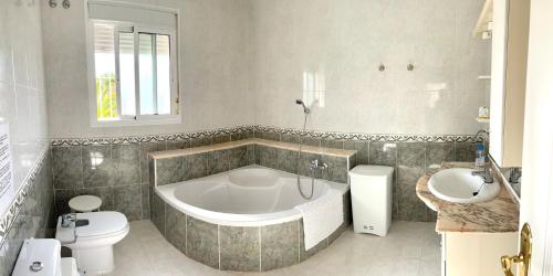 a bathroom with a tub and a toilet and a sink at Casa Sara - Private Villa with Private Pool in Ciudad Quesada