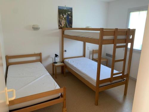 une chambre avec deux lits superposés et une fenêtre dans l'établissement Le Petit Bois 46, à Leyme