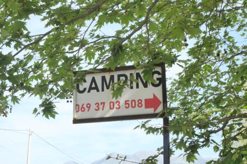 a sign that says dancing under a tree at Skendo Camping in Delvinë