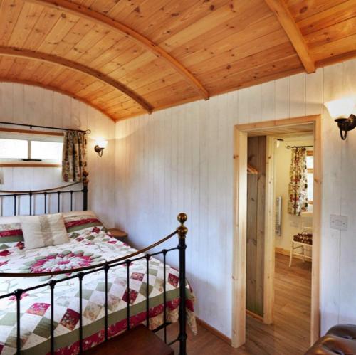 a bedroom with a bed and a wooden ceiling at Finest Retreats - Shepherds Retreat at Morrells Wood in Shrewsbury