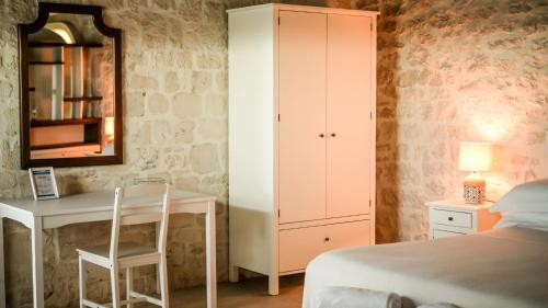 a bedroom with a bed and a desk and a cabinet at Masseria Surace in Noci