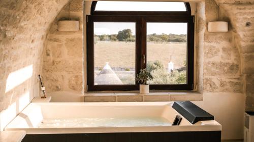a bath tub in a room with a window at Masseria Surace in Noci