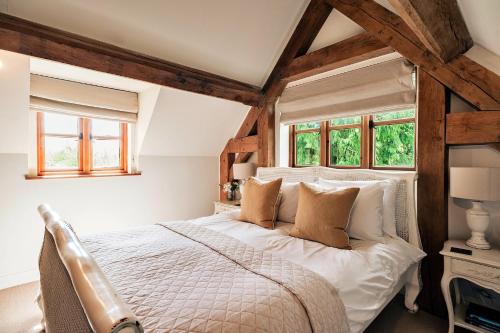 a bedroom with a large bed with wooden beams at Finest Retreats - Windfall Cottage in Tewkesbury