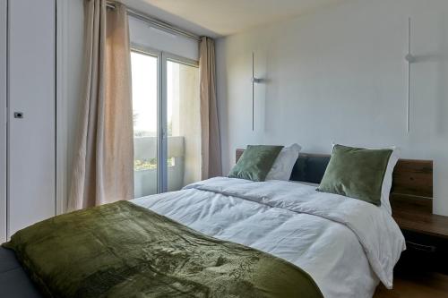 une chambre avec un grand lit avec une fenêtre dans l'établissement Le 13 Myosotis - 10min du métro, à Rosny-sous-Bois