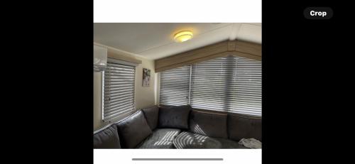 a living room with a couch and a window at Haven Holiday Park Orchards in Saint Osyth